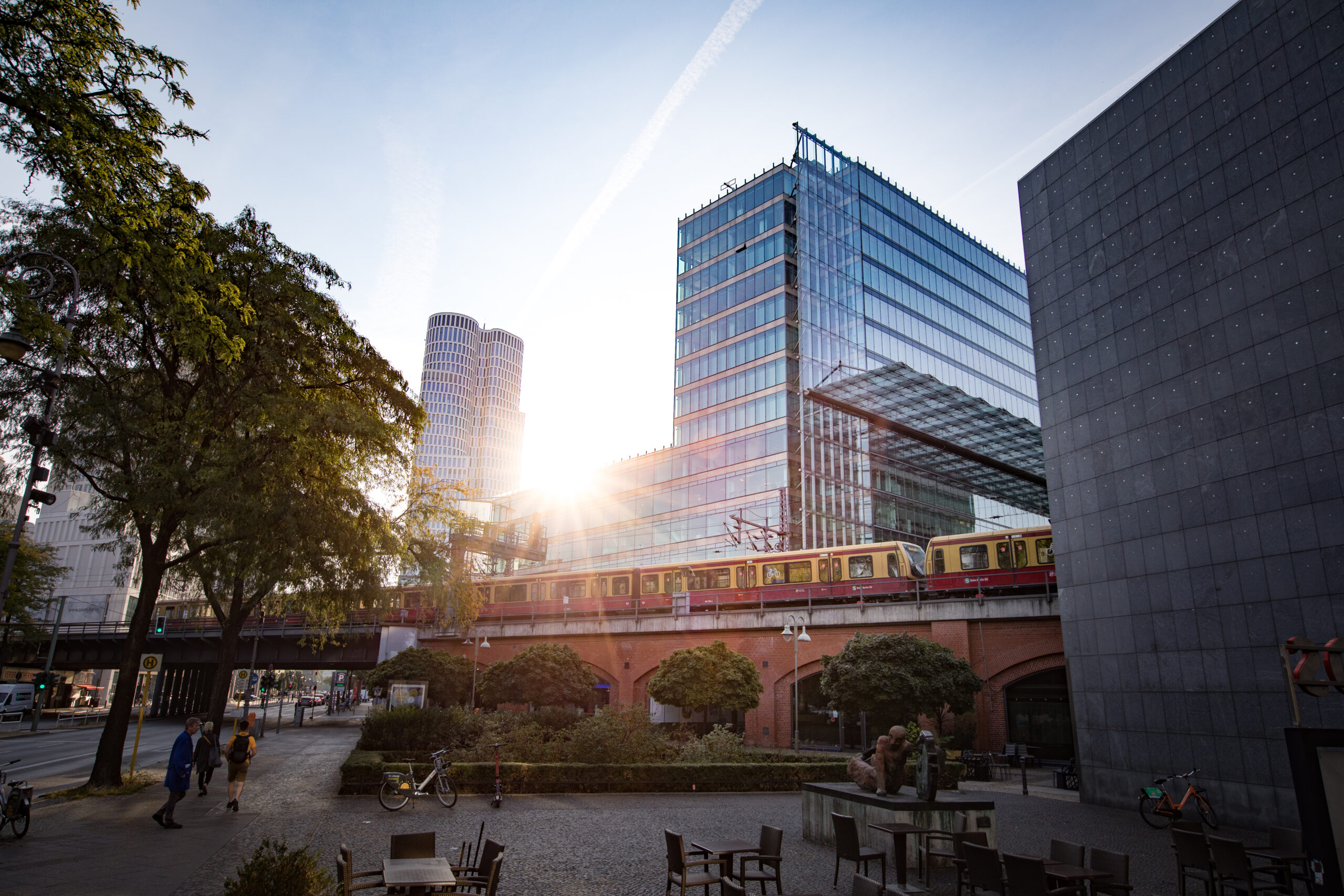 A train going over a bridge in a city, where Headquarter is located